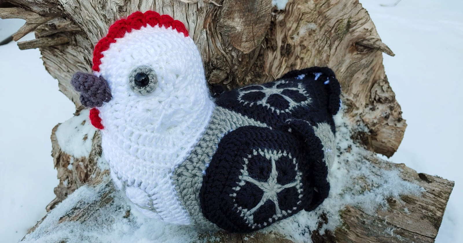 Crocheted hen sitting on a log